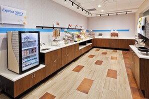 A modern breakfast area with a refrigerator, cereal, fruit, and a coffee machine. - Holiday Inn Express & Suites Cartersville by IHG (Cartersville)