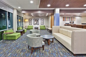 A hotel lobby with seating areas, a reception desk, and artwork on the walls. - Holiday Inn Express & Suites Cartersville by IHG (Cartersville)