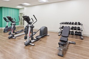 A gym with cardio machines, a bench, and a rack of dumbbells. - Holiday Inn Express & Suites Cartersville by IHG (Cartersville)