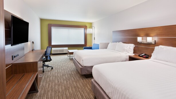 A hotel room with two beds, a desk with a flat-screen TV, a chair, and a large window with blinds. - Holiday Inn Express & Suites Cartersville by IHG (Cartersville)