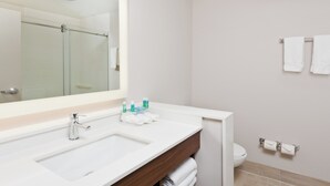 A modern bathroom with a large mirror, a white sink, and a glass shower enclosure. - Holiday Inn Express & Suites Cartersville by IHG (Cartersville)