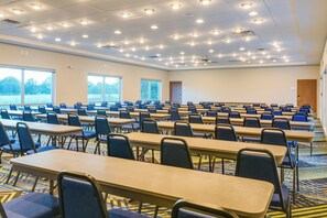 A conference room with multiple tables and chairs, large windows, and a carpeted floor. - Holiday Inn Express & Suites Russellville by IHG (Russellville)