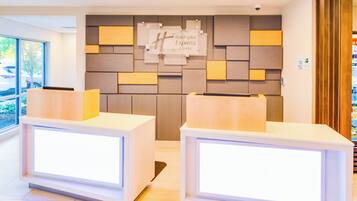 Un comptoir d’accueil avec une enseigne indiquant « Holiday Inn Express & Suites ».