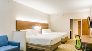 Ein Hotelzimmer mit zwei Betten, einem Schreibtisch, einem Stuhl und einem kleinen Kühlschrank.