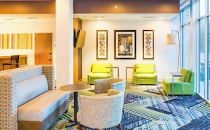 A hotel lobby with seating areas, a coffee table, and artwork on the walls. - Holiday Inn Express & Suites Russellville by IHG (Russellville)