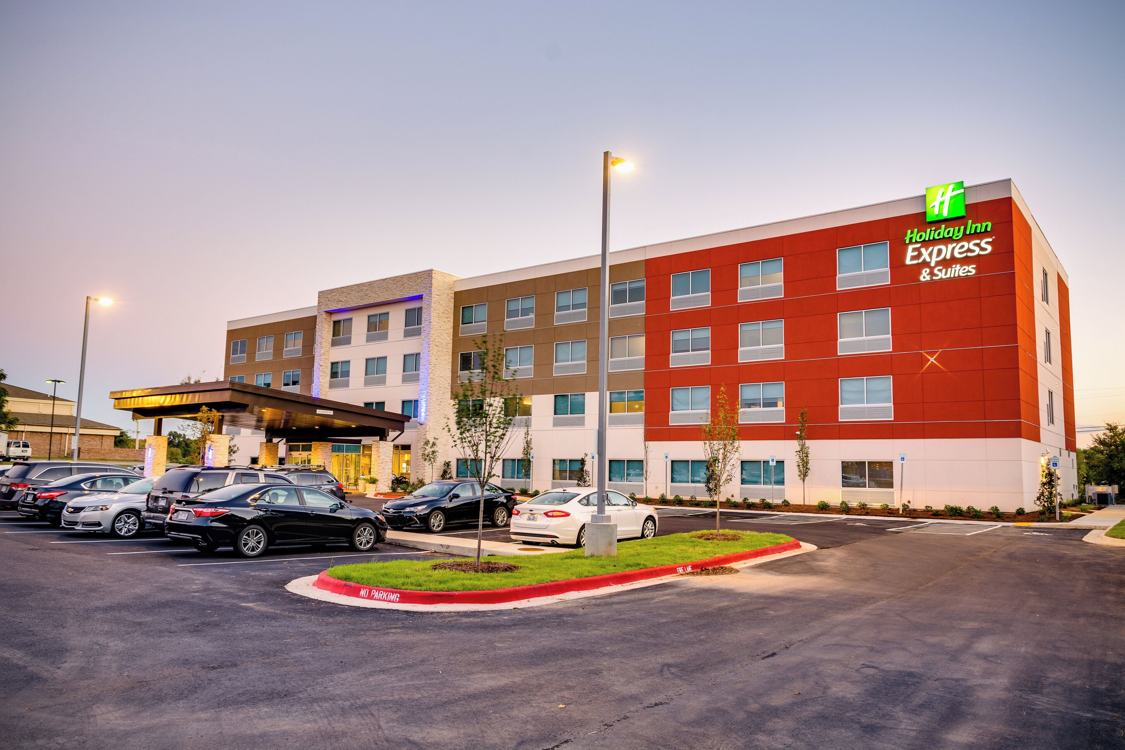 A Holiday Inn Express hotel with multiple parking spaces and a well-lit entrance.