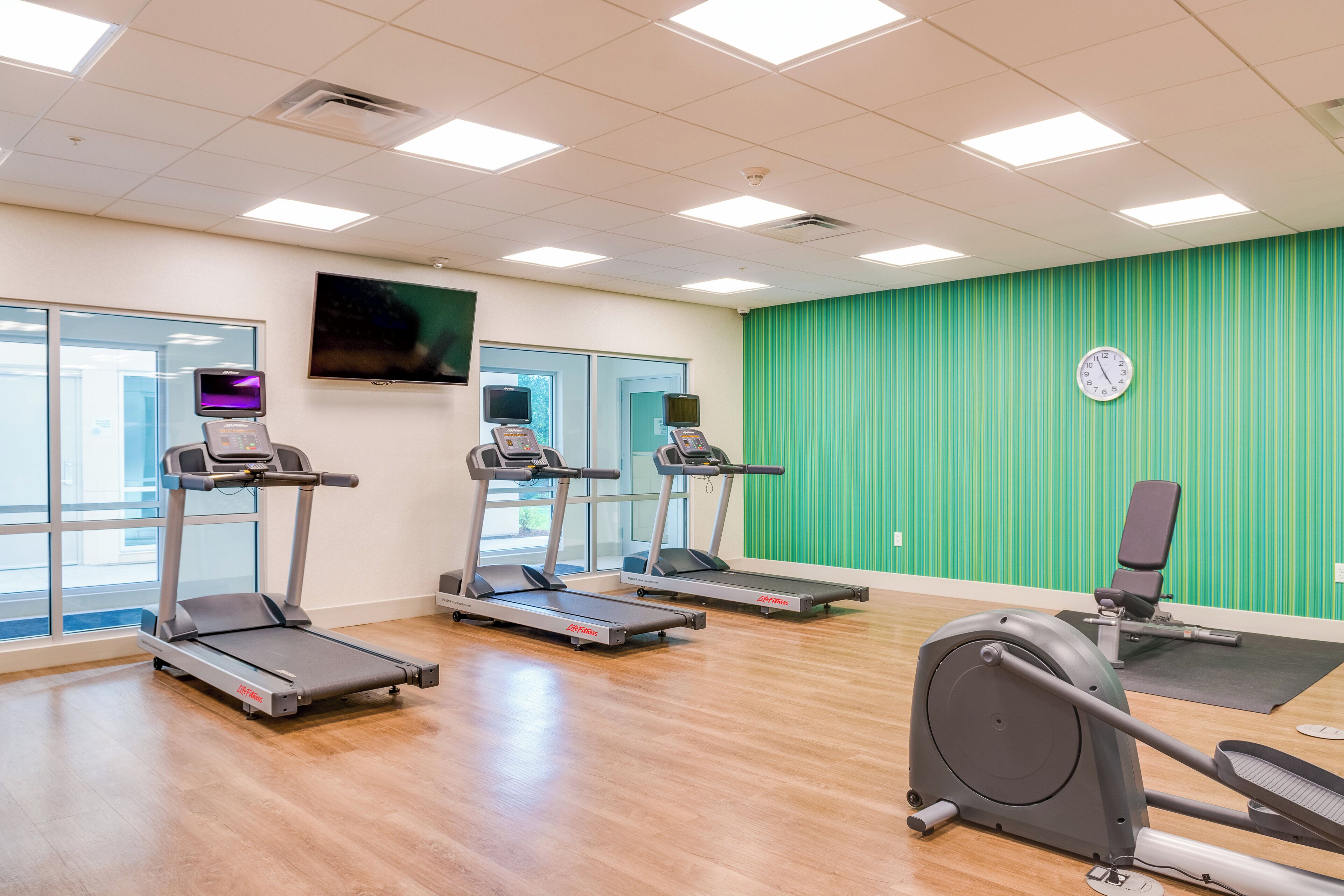 A gym with treadmills, a stationary bike, and a rowing machine.