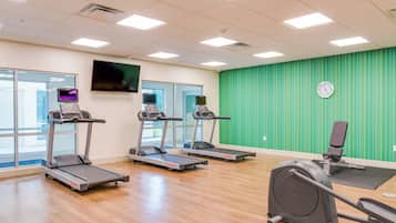 A gym with treadmills, a stationary bike, and a rowing machine.