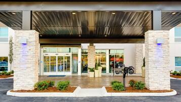 A building entrance with a covered walkway, glass doors, and a mailbox.