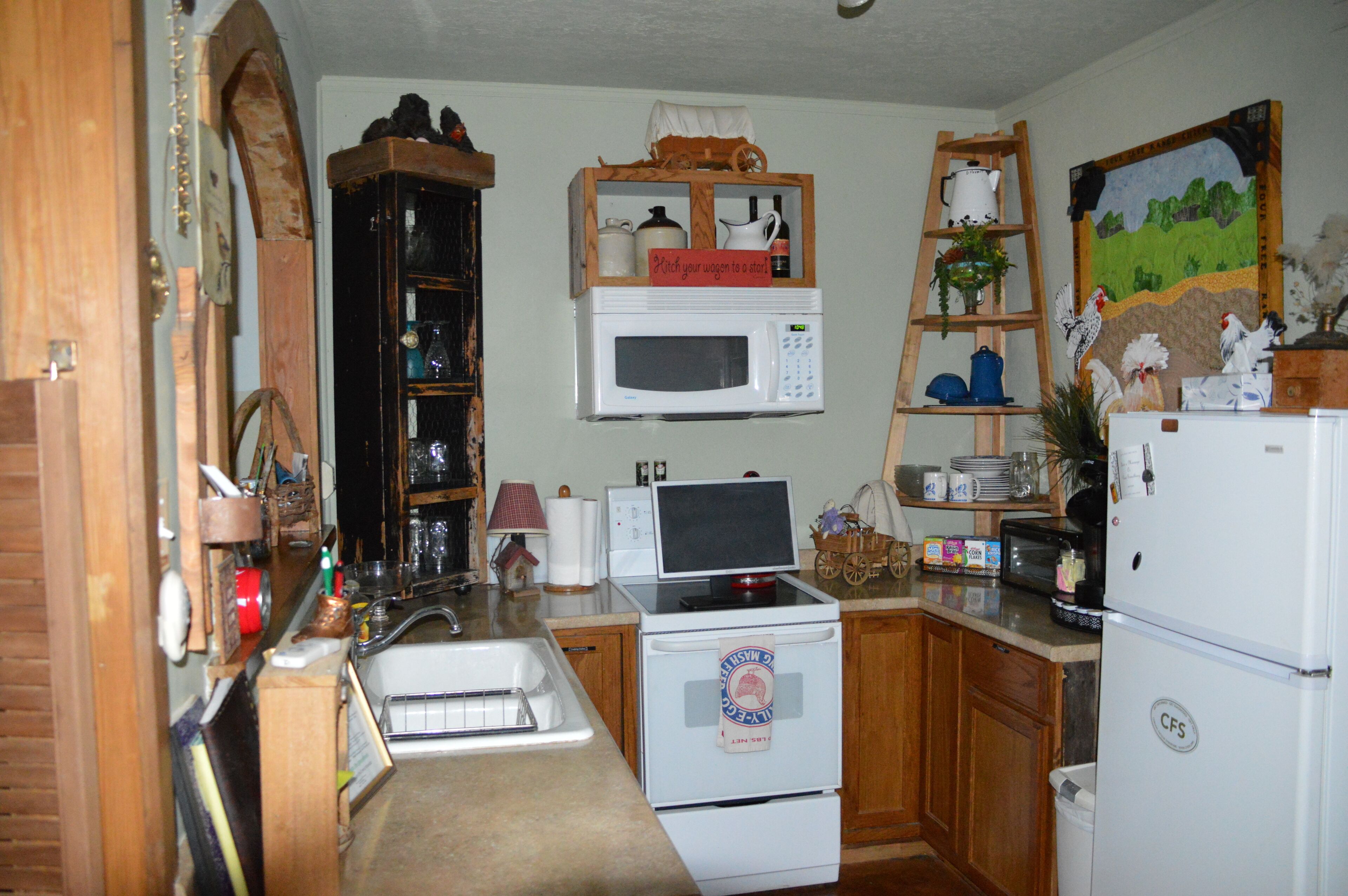 A kitchen with wooden cabinets, a microwave, a stove, and a refrigerator.