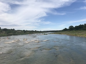 Ein Fluss mit Felsen und einigen Menschen im Wasser.