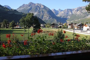A mountain village with traditional houses, a clear sky, and a view of the mountains.