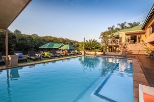 Una piscina al aire libre, sillones reclinables de piscina