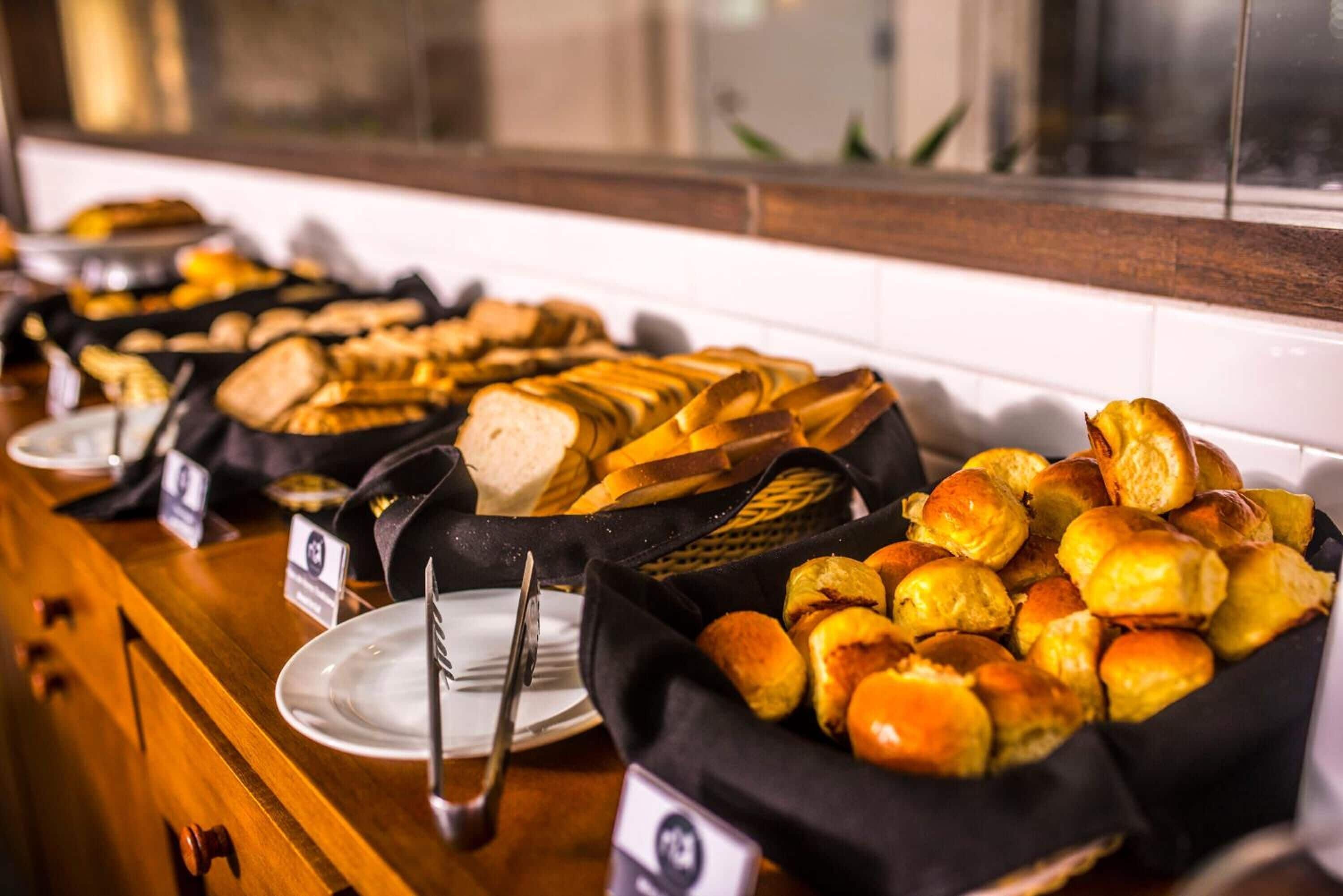 A buffet with various breads and pastries.