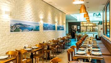 Un restaurante con paredes de ladrillo, mesas y sillas de madera.