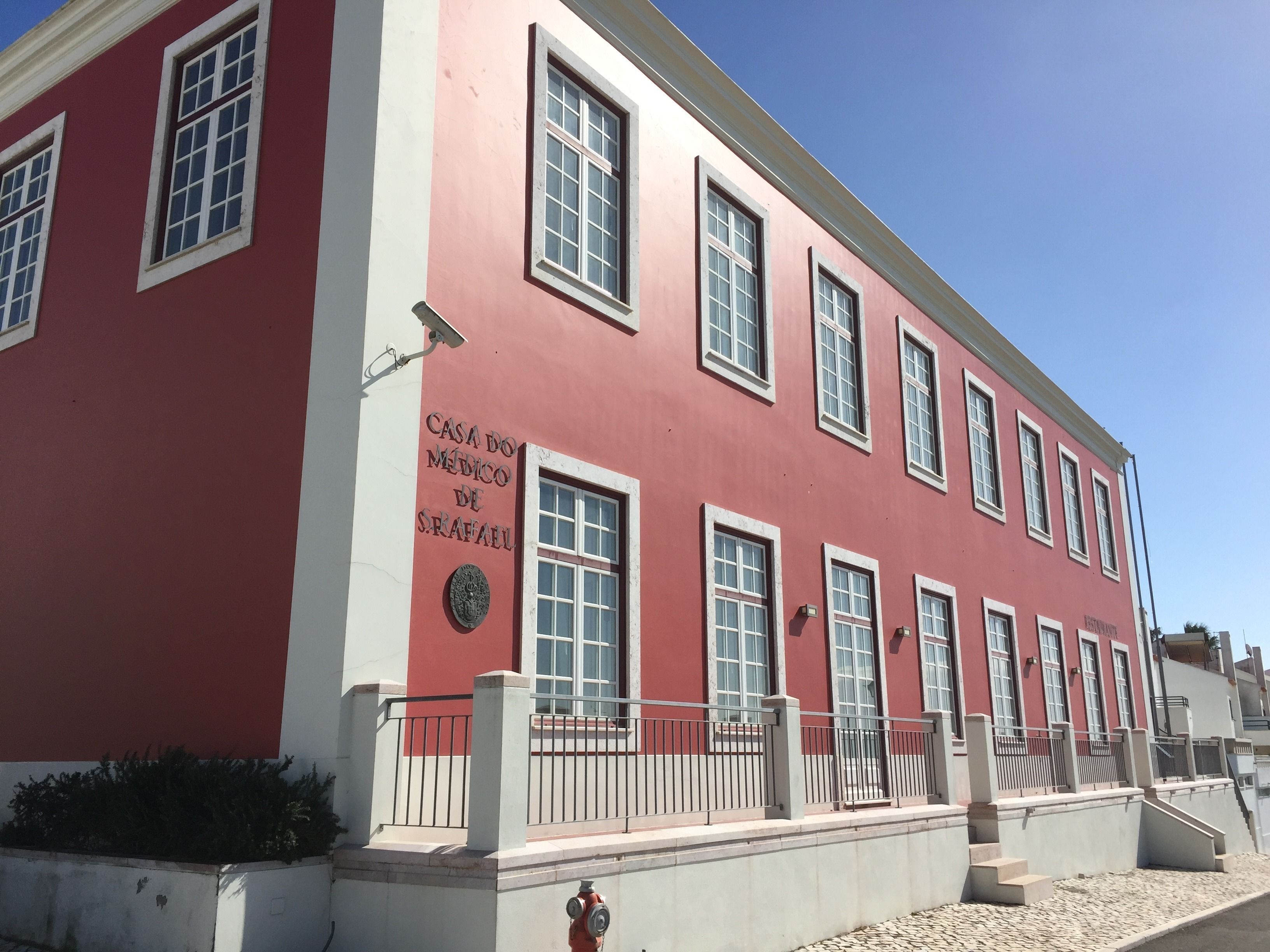 Un edificio rojo con múltiples ventanas y un letrero que dice "Casa do Medico de S. Fial".