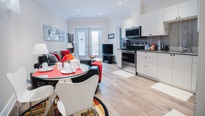 A modern apartment with a dining area, kitchen, and living room.