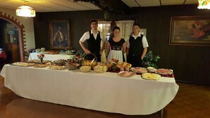 Une table de buffet garnie de différents plats et un tableau accroché au mur.