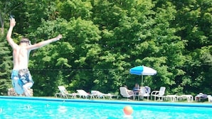 Une piscine avec des chaises longues et des parasols.