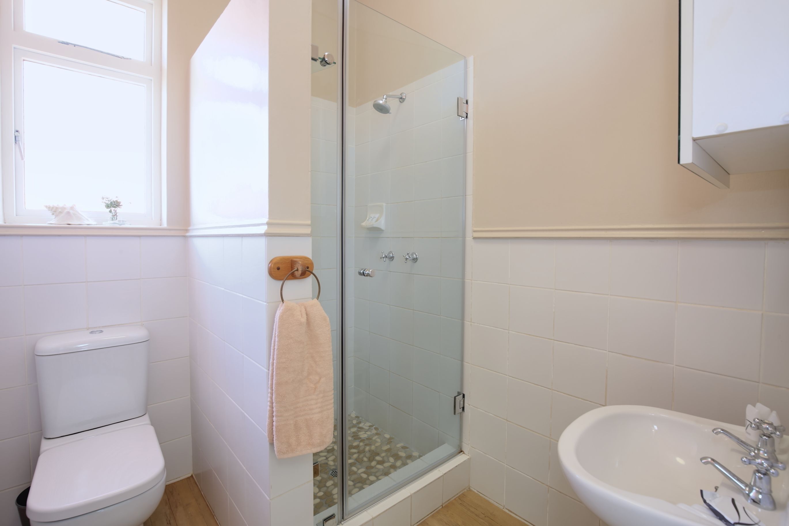 Ein Badezimmer mit Toilette, einer Duschkabine und einem Waschbecken.