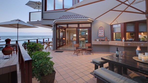 Een terras aan de kust met buitenmeubilair, een bar en uitzicht op zee.