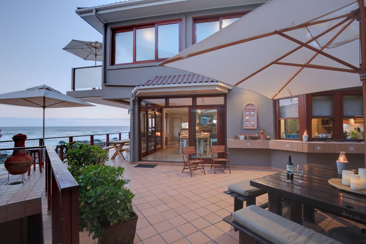 Een terras aan de kust met buitenmeubilair, een bar en uitzicht op zee.