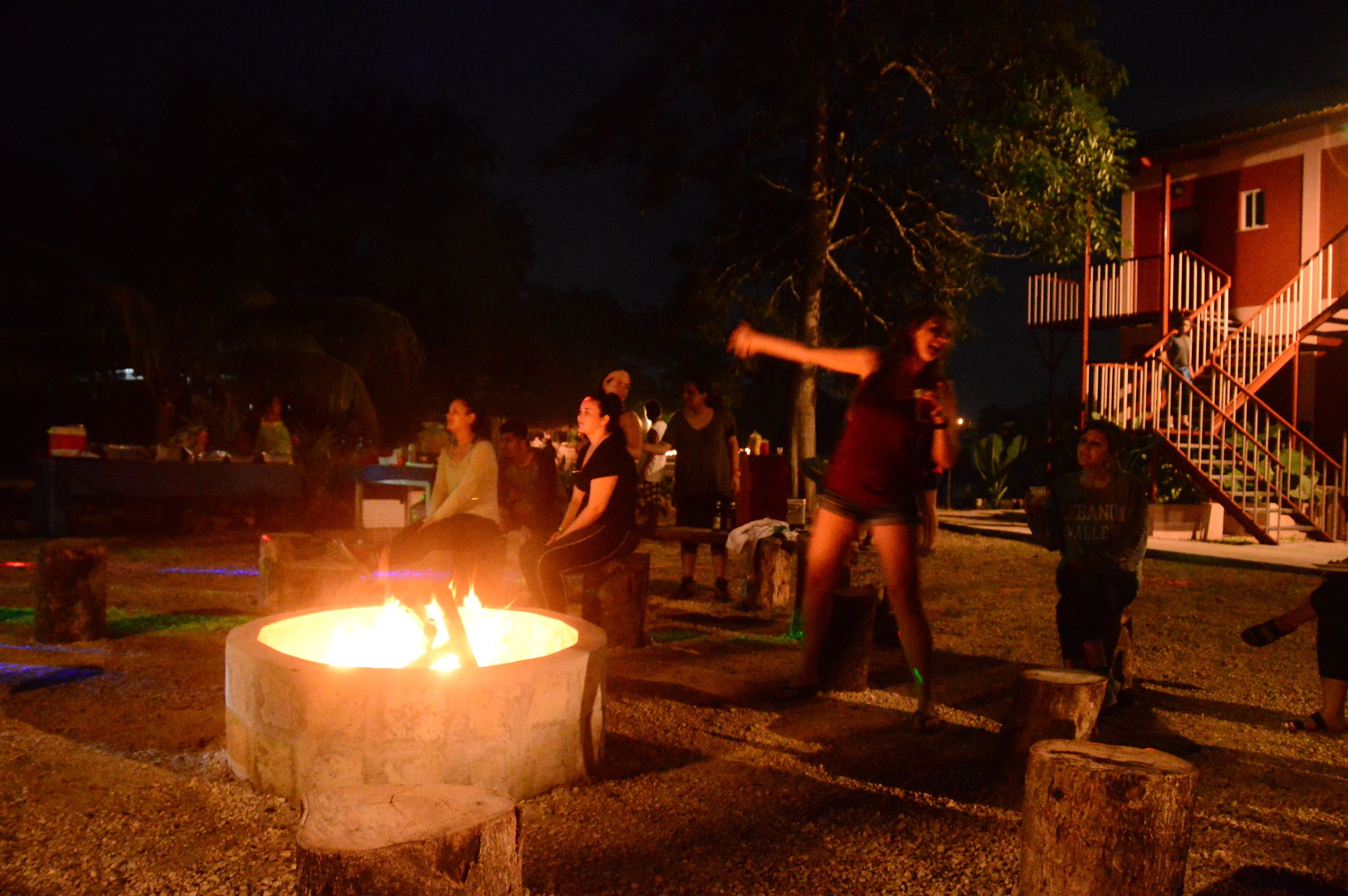 A group of people gathered around a campfire at night.