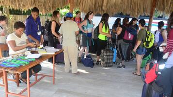 Un grupo de personas reunidas alrededor de una mesa con diversos objetos, posiblemente para un taller o actividad.