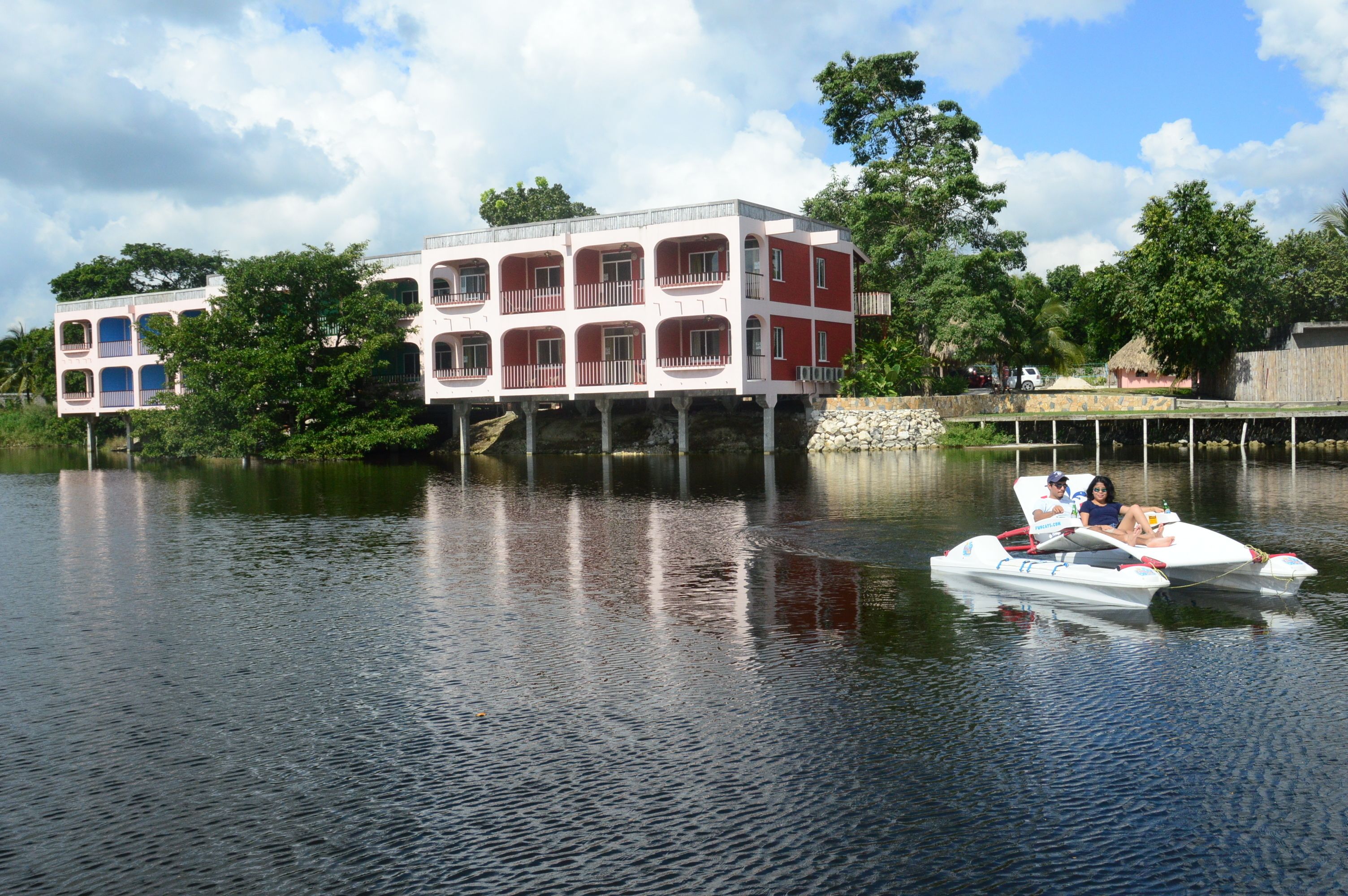 A houseboat with a balcony, floating on calm water.