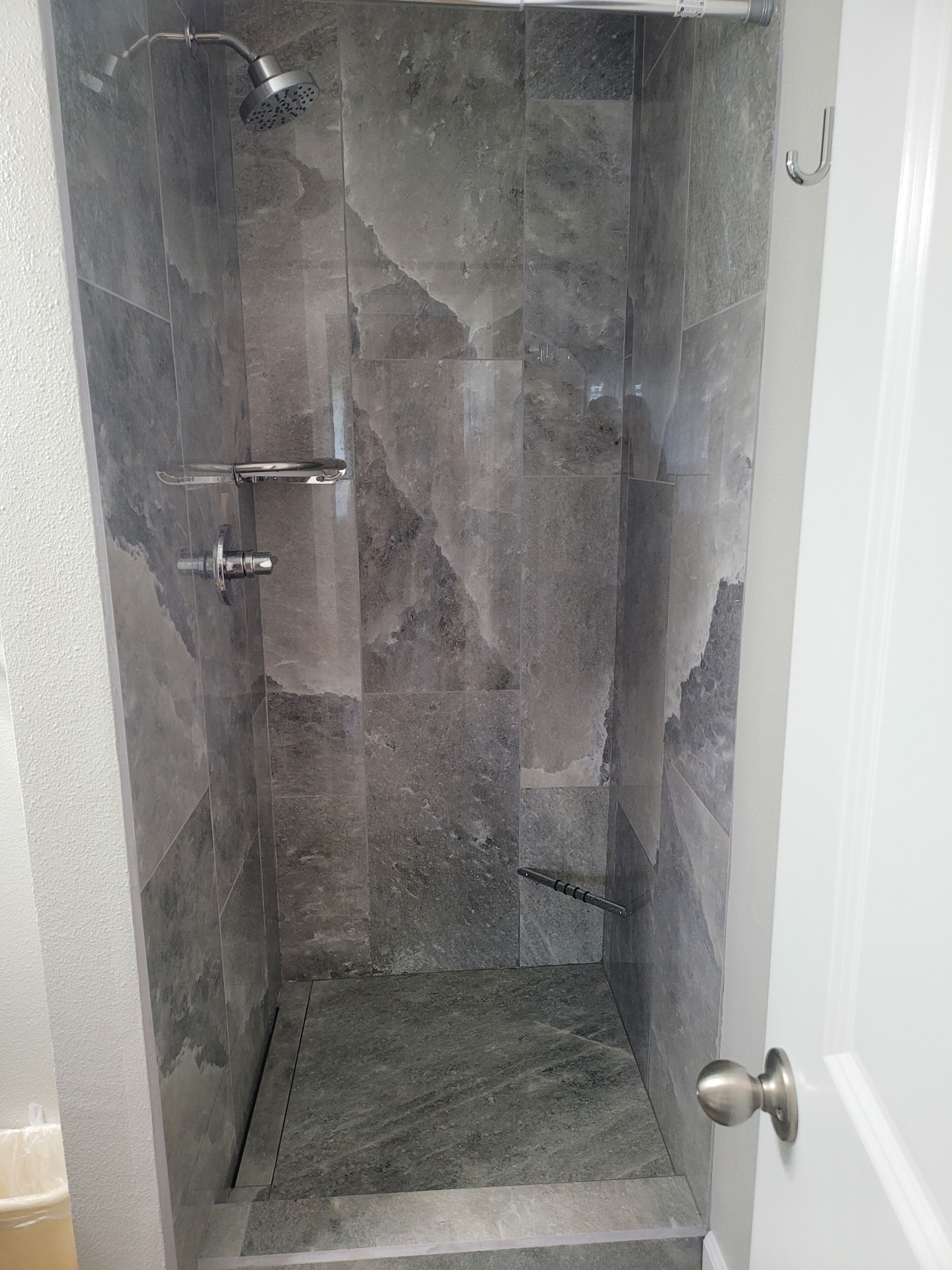 Eine Dusche mit verstellbarer Duschbrause und Halterung.