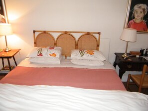 A hotel room with a bed, two bedside lamps, a nightstand, and a framed picture on the wall. - Valley Guest House (Port Elizabeth)