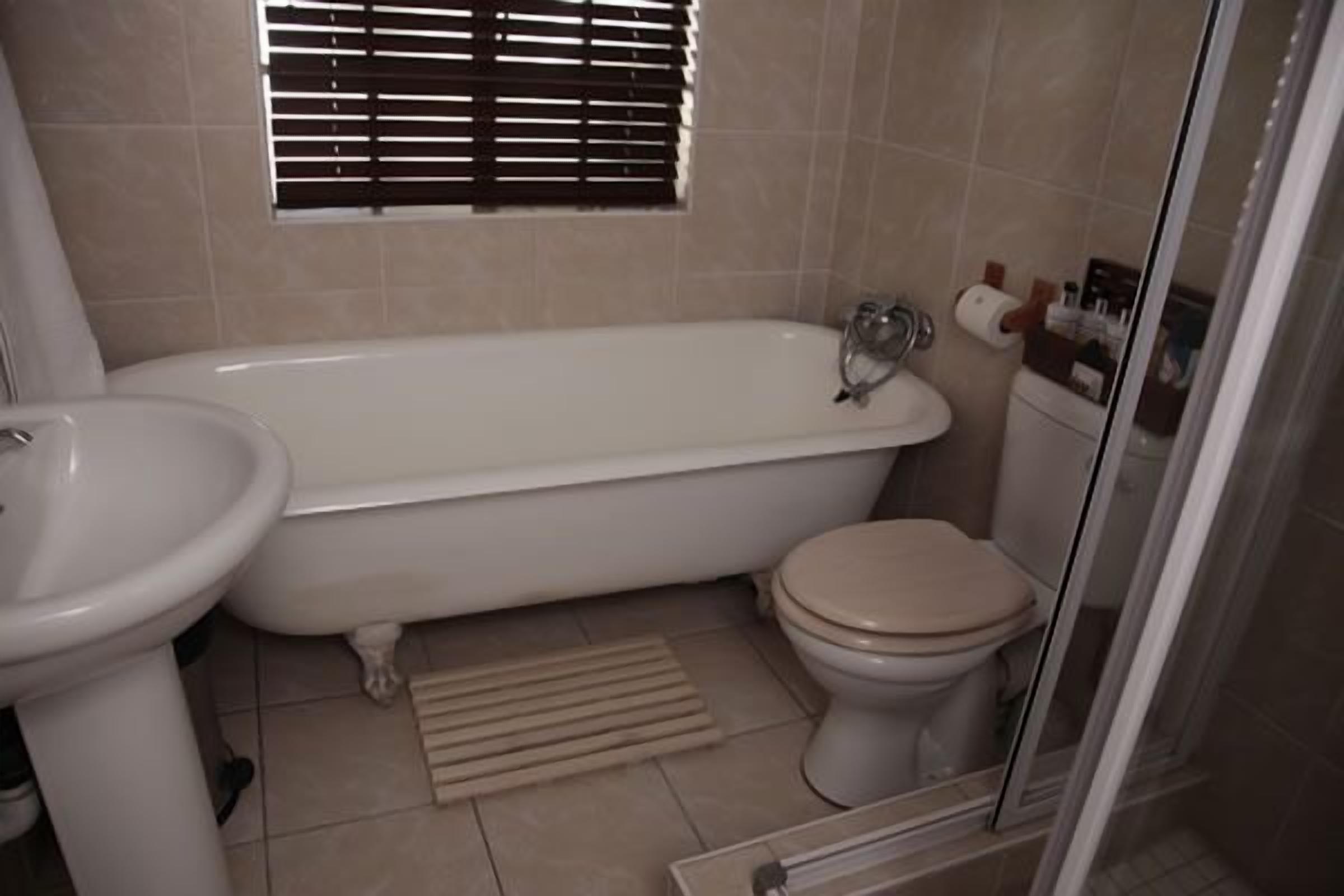 A bathroom with a bathtub, toilet, and sink.