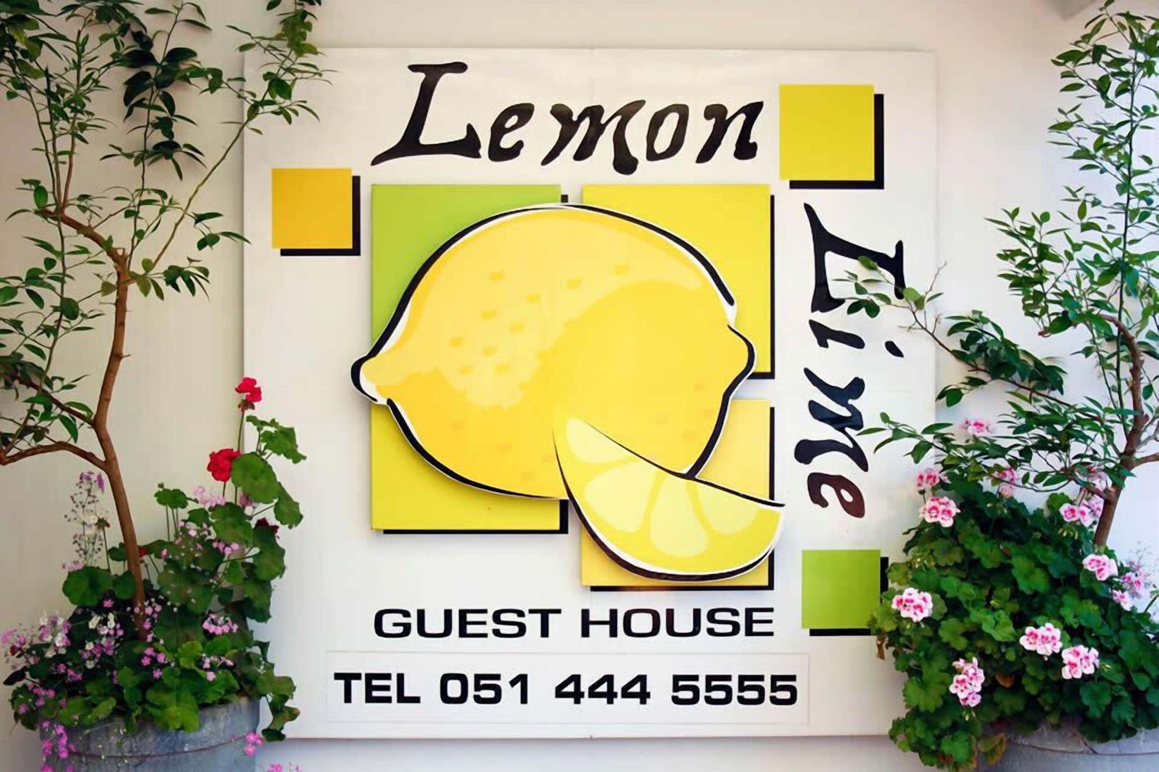 A wall sign for 'Lemon Lime Guest House' with contact information.