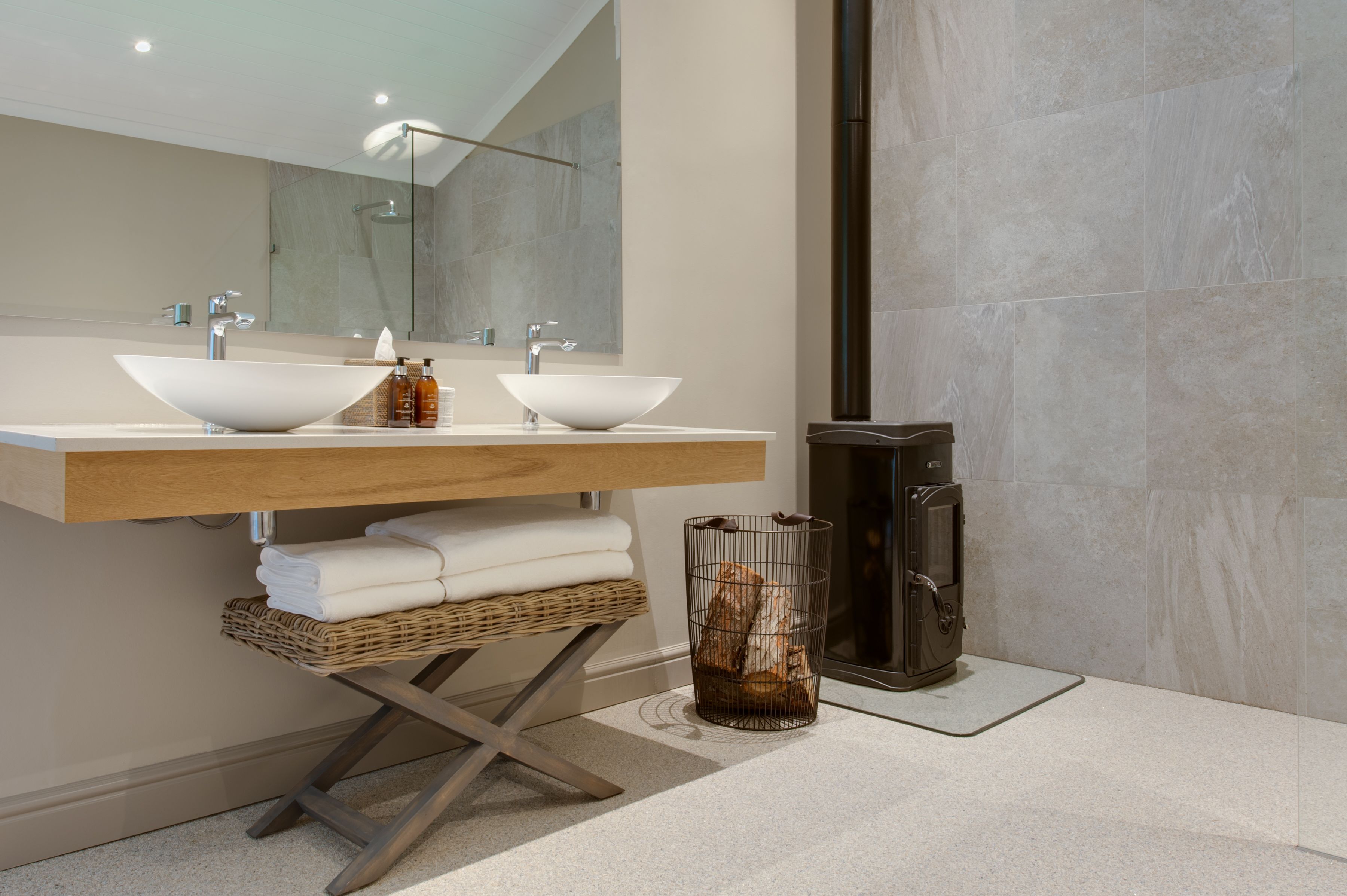 A modern bathroom with two sinks, a large mirror, and a heated towel rail.