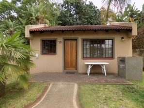 A small building with a tiled roof, a wooden door, and a window. - Eagle's Nest Chalets (Hazy view)
