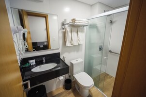 Un bagno moderno con lavandino nero, WC bianco e cabina doccia in vetro.