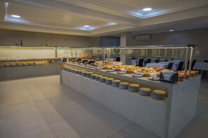 A buffet setup with various food items and plates arranged on a counter.