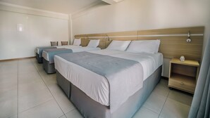 A hotel room with two beds, a bedside table, a chair, and a small table with a telephone. - Varadero Palace Hotel (Florianópolis)