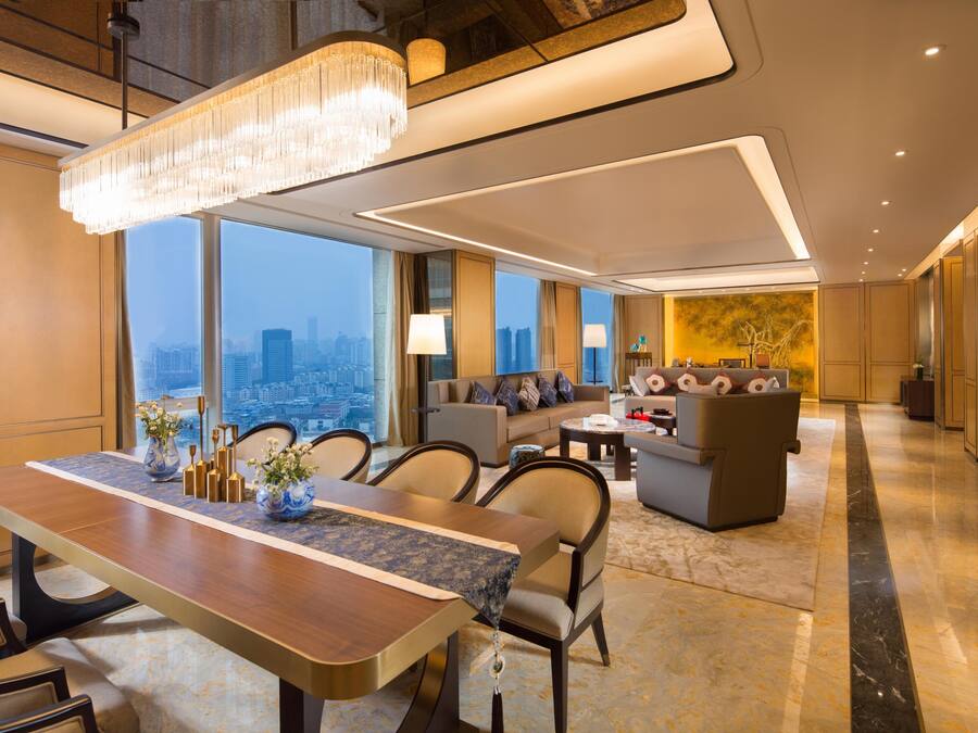 Un moderno vestíbulo de hotel con zona de comedor, asientos y vistas a la ciudad.