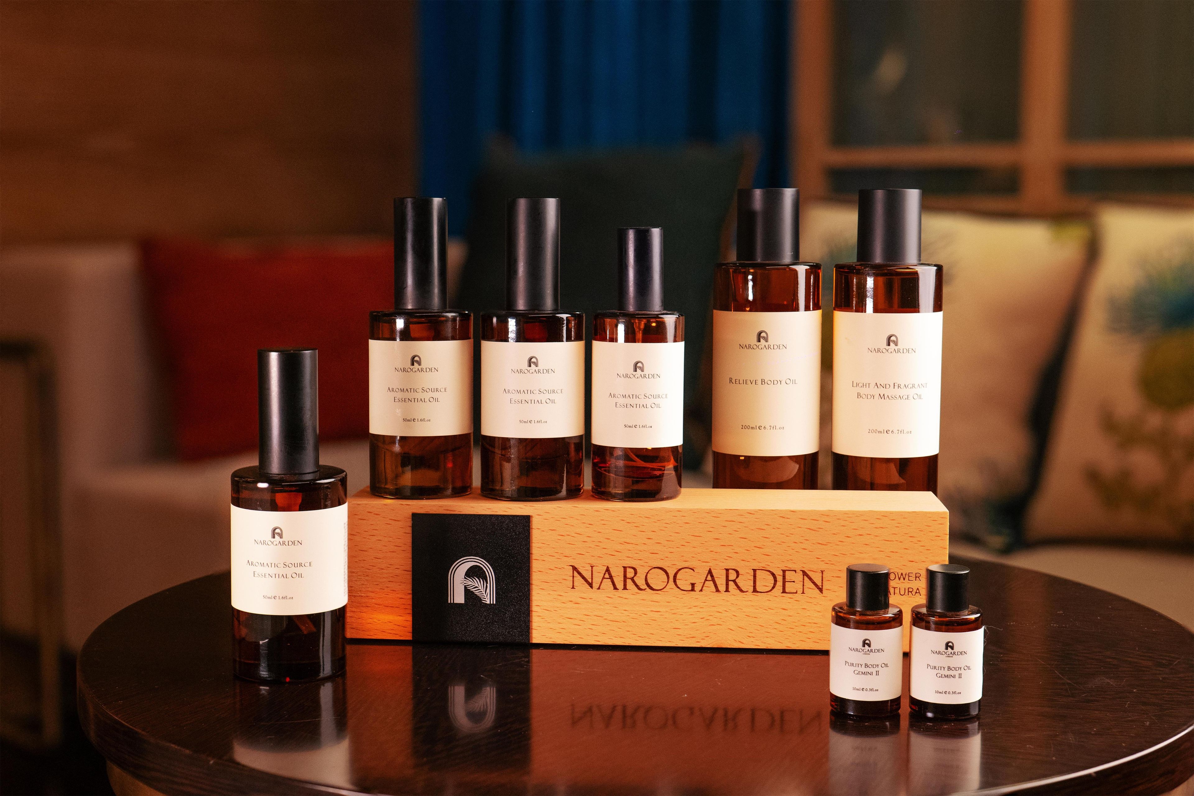 A collection of Narogarden essential oil bottles arranged on a wooden table with a Narogarden box.