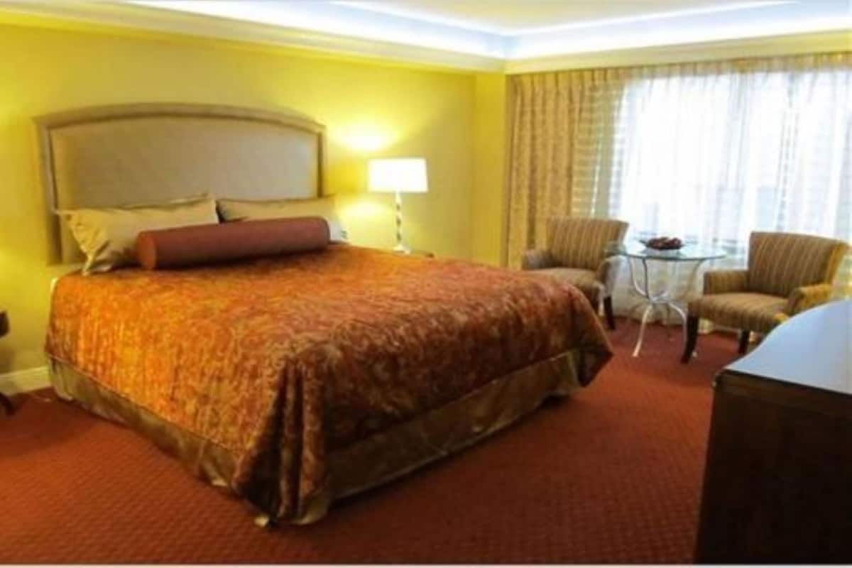 Una camera d'albergo con un letto grande, una scrivania, una sedia e un tavolino.