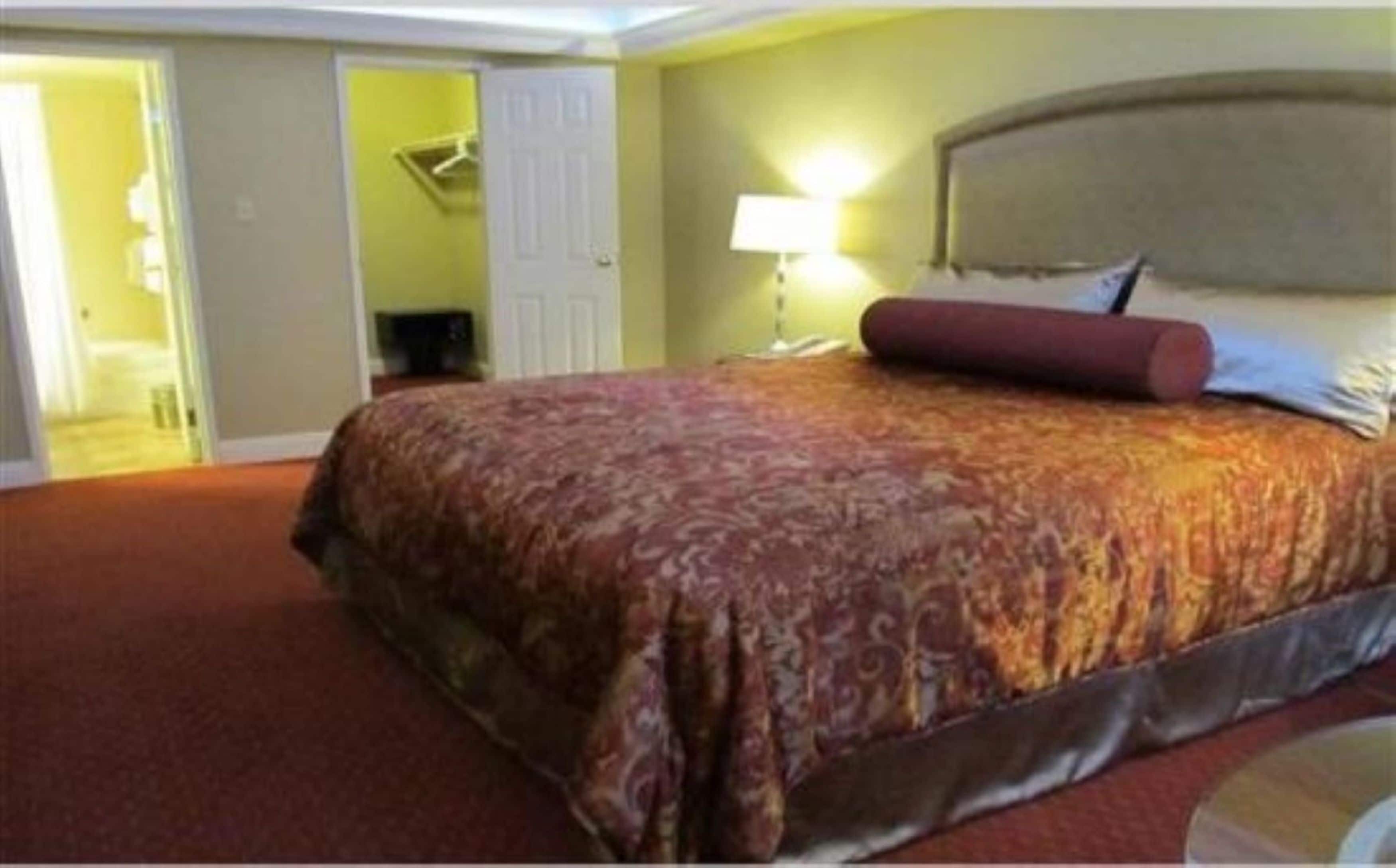 Une chambre d’hôtel avec un grand lit, une lampe de chevet et une porte donnant sur un couloir.