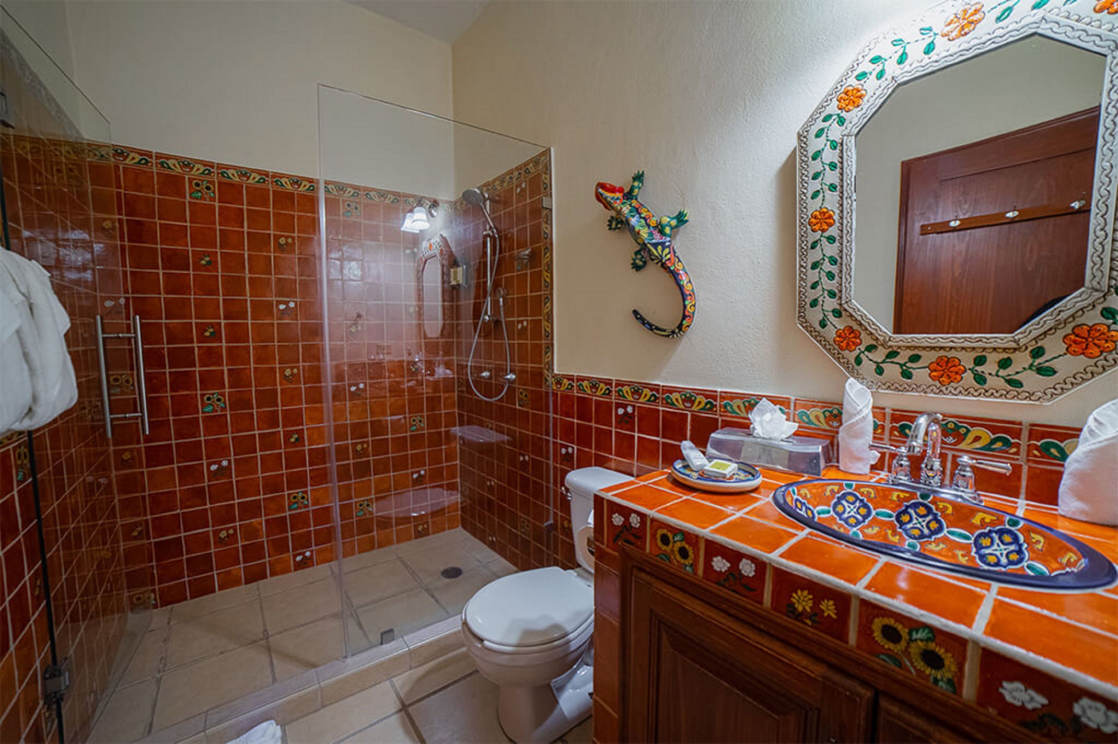 A bathroom with a shower, toilet, and sink.