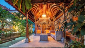An indoor area with a tiled floor, wicker furniture, and a chandelier. - The Kutaya (Kuta)