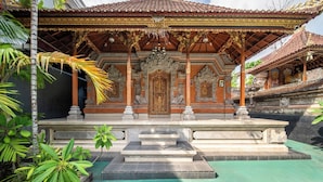 Een traditionele tempel met rijk versierde architectuur, een centraal heiligdom en een omliggende tuin.