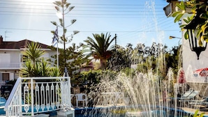 A swimming pool with water jets, a white railing, and a flag.