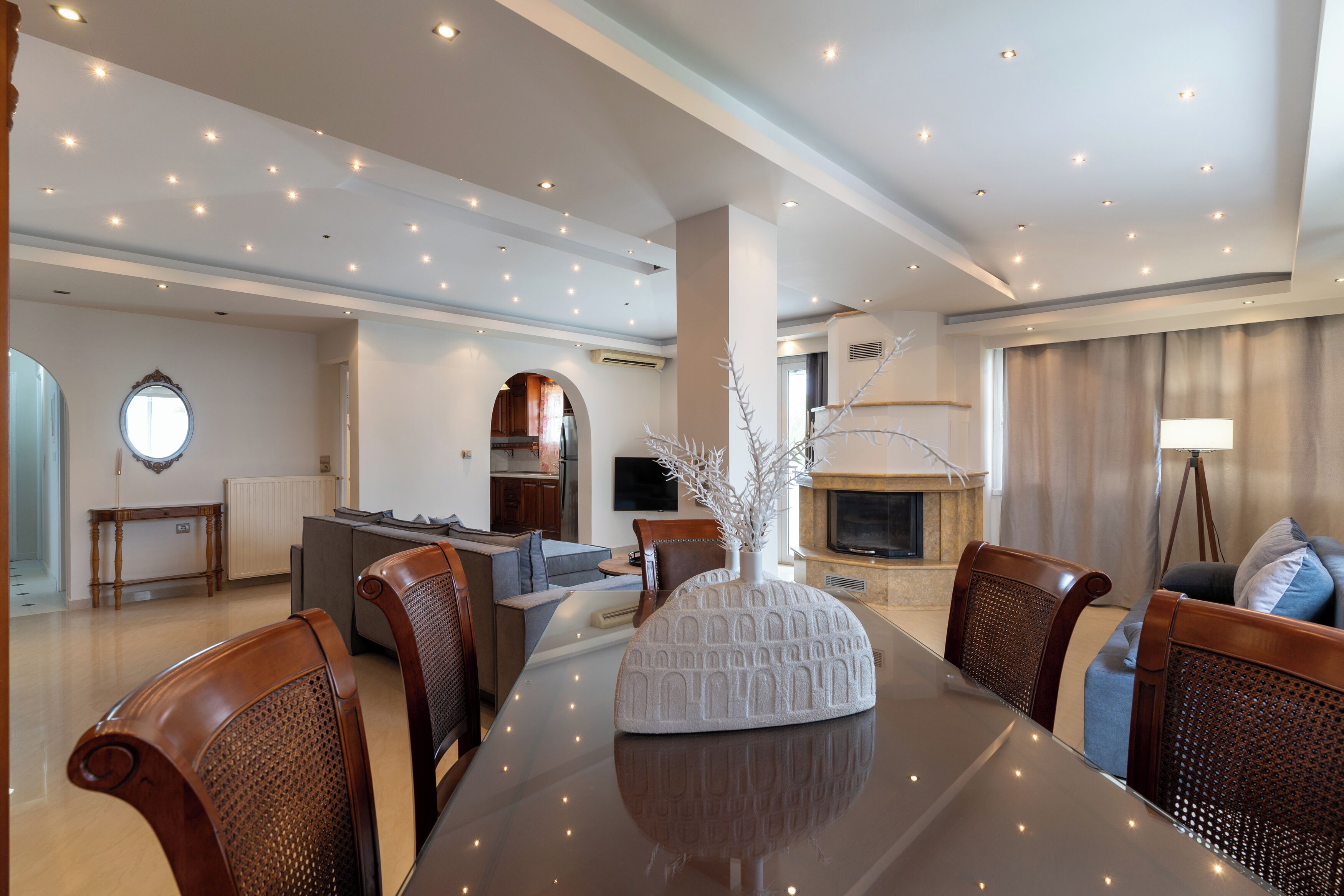 A spacious living room with a dining area, modern furniture, and a fireplace.