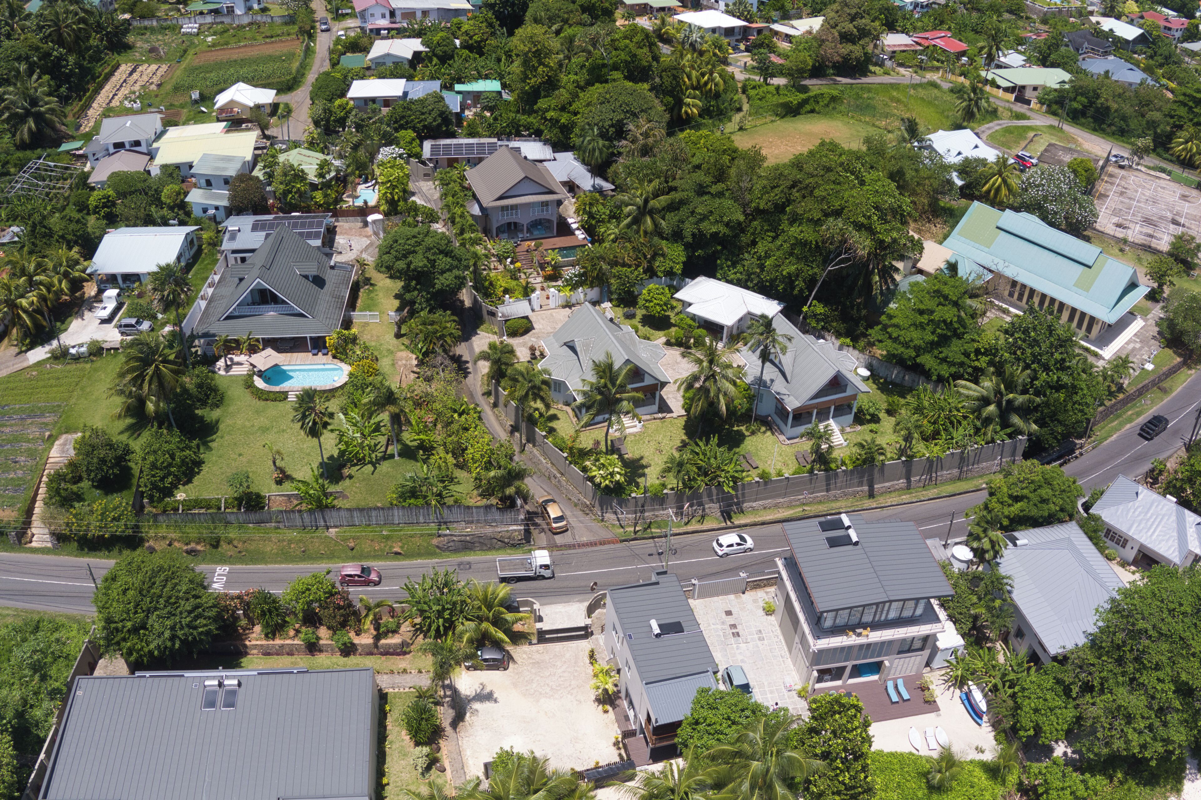 An aerial view of a residential area with houses, roads, and greenery.