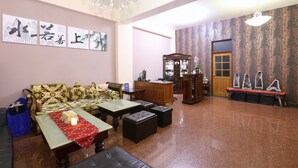 A traditional living room with a sofa, coffee table, and a cabinet. - Mozhu B&B (Hualien City)