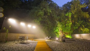Un espacio al aire libre con terraza de madera, asientos y una piscina pequeña.